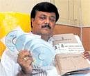 BBMP JD(S) leader Padmanabha Reddy displays CDs and files said to be containing details of the Rs 169-crore scam  in the Palike, on Wednesday. DH Photo