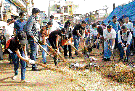 Software engineers clean the KR Market premises in the City on Sunday. DH Photo