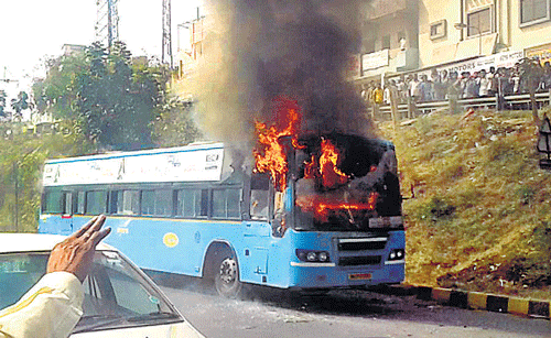 burning bus: People watch as a BMTC bus caught fire near Laggere main road  on Thursday. DH photo
