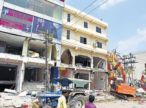 BBMP employees demolish multi-storeyed buildings on Banasavadi lake land at 80 Ft Road in Bengaluru on Saturday. DH Photo by Satish Badiger
