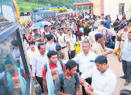 Passengers of the Bengaluru-Karwar/Kannur Express wait to board a bus  to their destinations as the train halted at the Sakleshpur station, following a mishap on the track, on Monday. dh photo