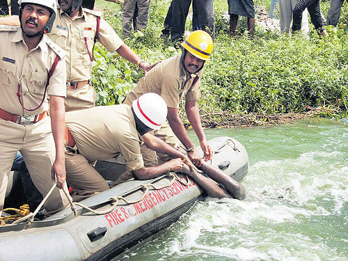 Emergency services personnel fish out on Thursday the body of 15-year-old Prakash (Right) who drowned in an SWD canal near Manyata Tech Park in the City on Thursday. KPN