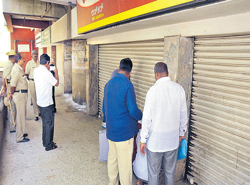 Palike officials seal a shop at Subhashnagar shopping complex for non-payment of rents. DH PHOTO