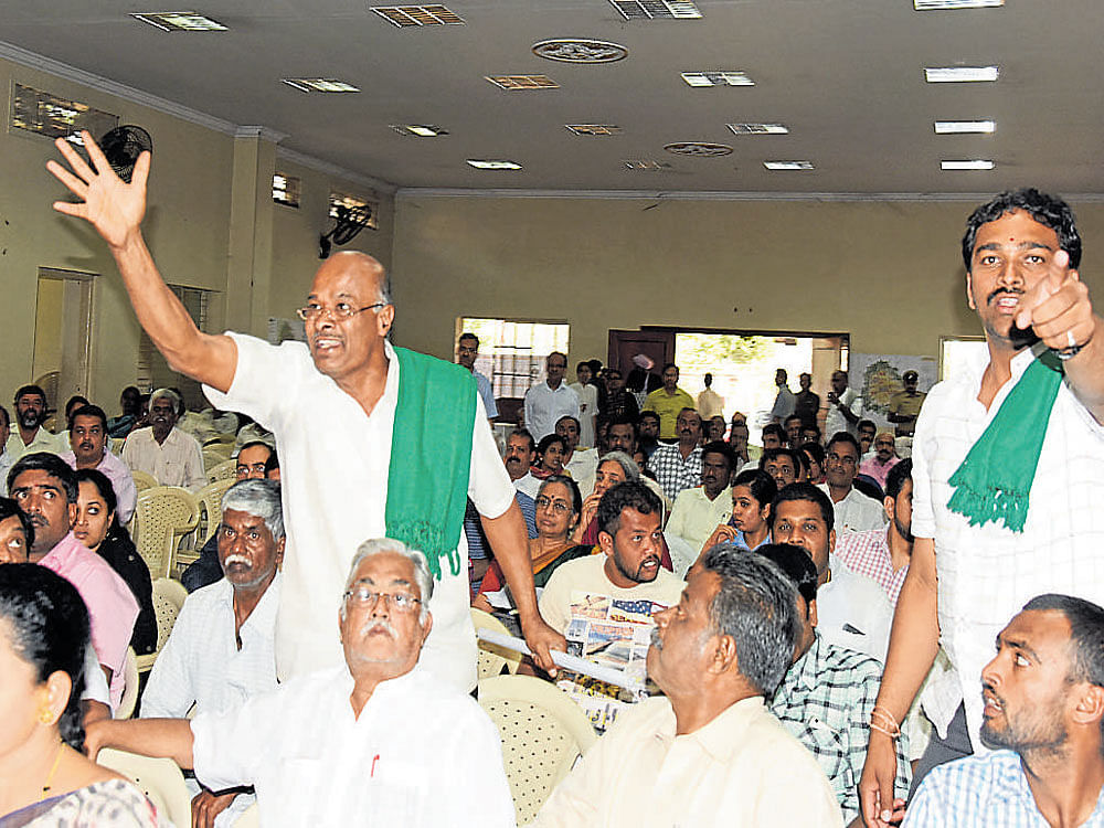 Bettahalasur farmer Nanjundappa and Raitha Sangha members argue with BDA officials  over the Revised Master Plan 2031 at a public consultation meeting on Wednesday. dh Photo