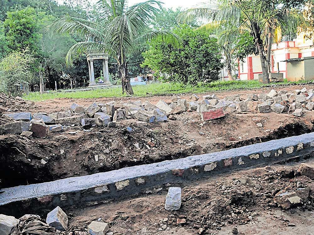 damage control: The BBMP on Tuesday started rebuilding the compound wall of the  Rameshwara temple in Chamarajpet, which was demolished for constructing Indira Canteen on Monday night. dh Photo