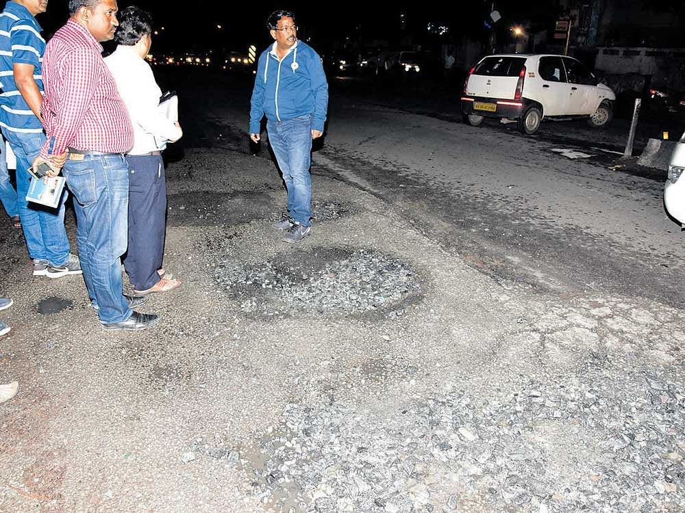 BBMP commissioner N Manjunath Prasad inspects potholes on 100 Feet Road in Indiranagar on Sunday night. DH photo