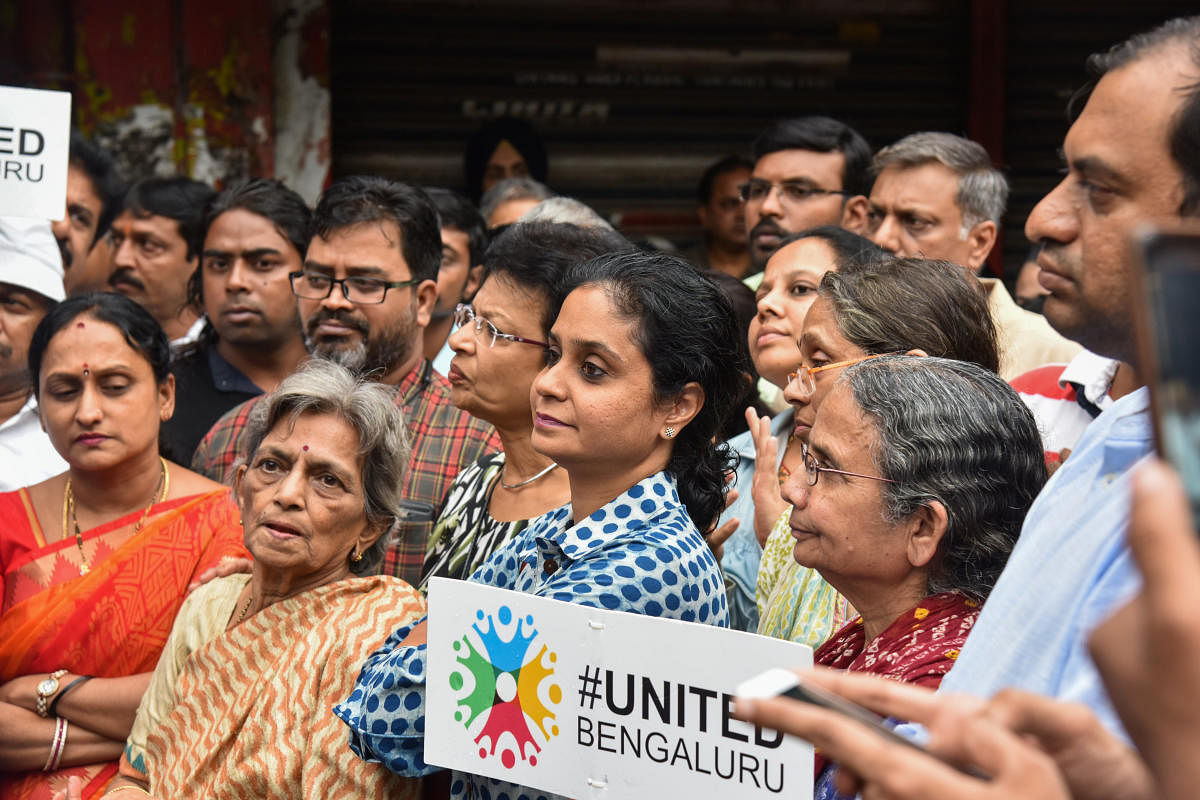 Residents protest against the redevelopment of the BDA shopping complex and the cutting down of trees in Indiranagar, Bengaluru, on Saturday. DH PHOTO/S K Dinesh