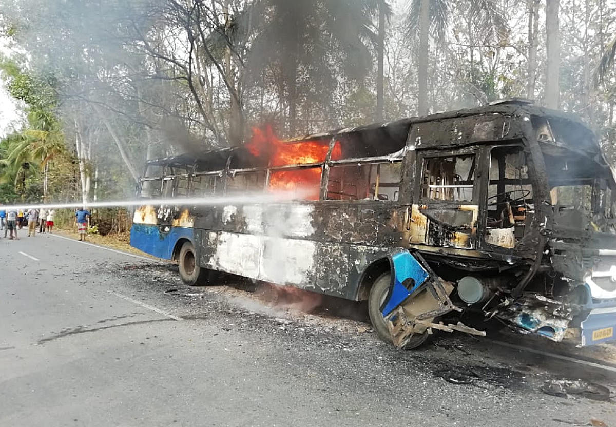 Remains of the day: The bus that caught fire after a bike rammed into it at Devagere cross near Kaggalipura on Monday evening.