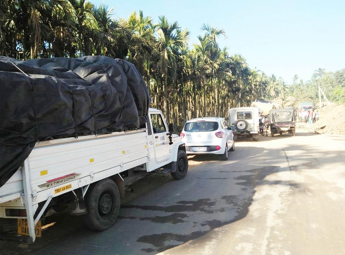 Vehicles lined up on National Highway 234 near Phalguni village in Mudigere on Thursday.