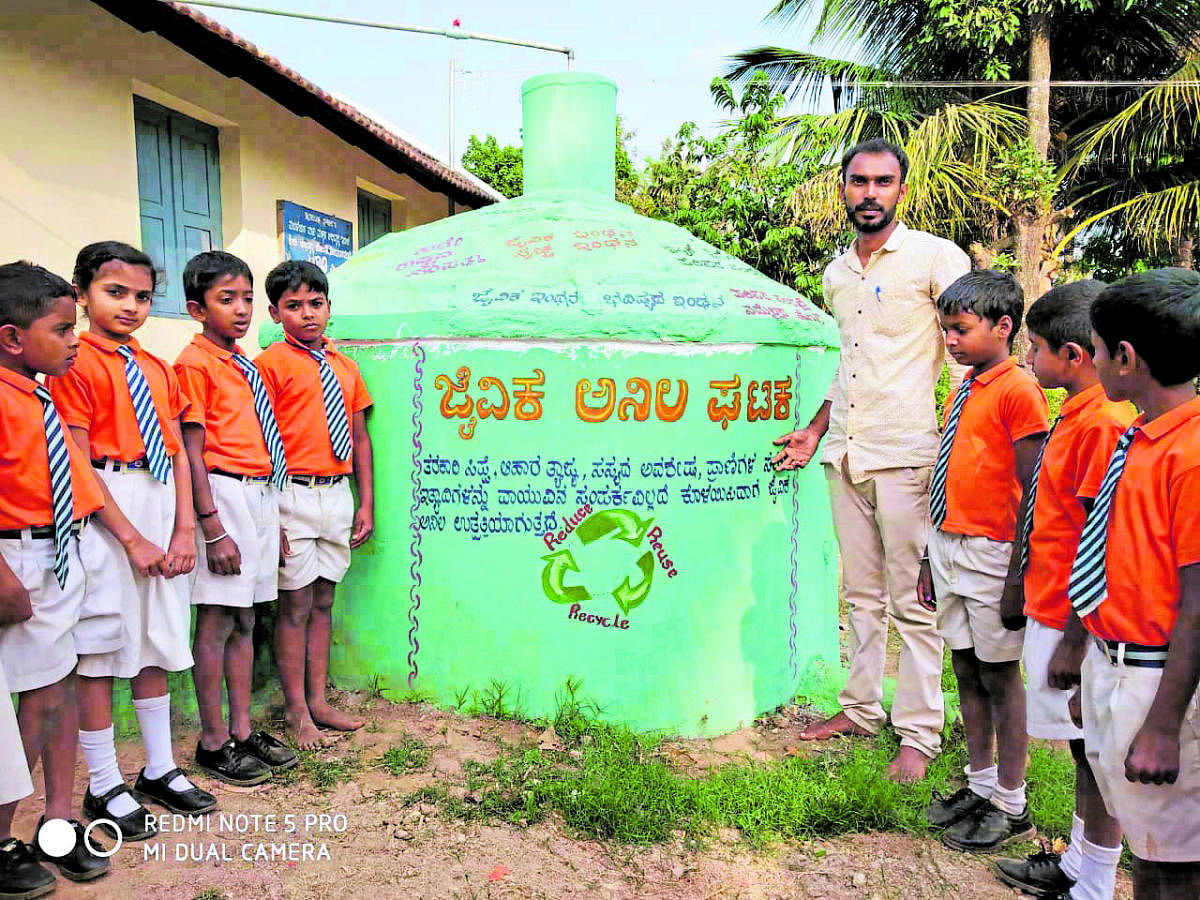 Students of Government lower primary school, Mullur, with their teacher C S Satish at the gobar gas unit in the school premises.