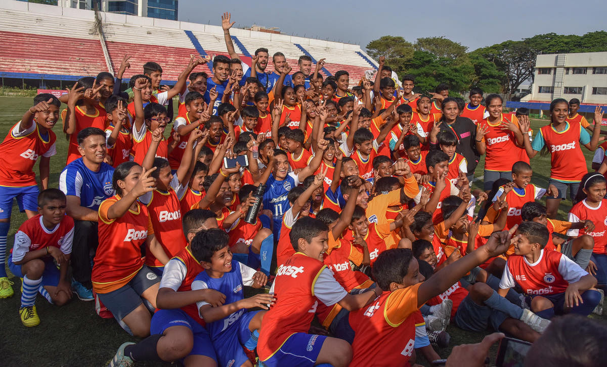 BFC captain Sunil Chhetri and former Indian cricket team captain and BFC brand ambassador Rahul Dravid pose with the kids at BFC's Play the Pros Event in Bengaluru on Saturday. DH Photo/ S K Dinesh