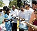 Happy indeed:  Minister R Ashoka (second from left), MP Ananthkumar and Mayor S K Nataraj distributing title deeds to slum dwellers in Jayanagar on Saturday. DH photo