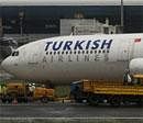 Airport authority officials gather for the recovery operation of the Turkish Airlines plane near the tarmac of Mumbai airport on Friday. AFP