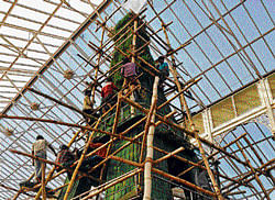 Workers busy creating a floral representation of the Eiffel Tower at Lalbagh Glass House for the Republic Day Flower Show, in Bangalore on Wednesday. DH Photo