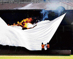 Quick response: Security personnel rush to extinguish the fire at the Chinnaswamy Stadium on Saturday. DH photo