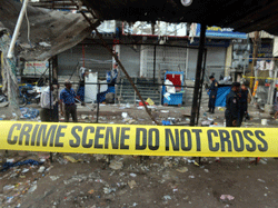 Police search for clues at one of the blast sites at Dilsukh Nagar in Hyderabad on February 22, 2013 the morning after twin bomb attacks killed 14 people and wounded dozens more. The bombings, the first to hit India since 2011, hit a mainly Hindu district in Hyderabad, a hub of India's computing industry which hosts local offices of Google and Microsoft among others and which has a large Muslim population. AFP PHOTO