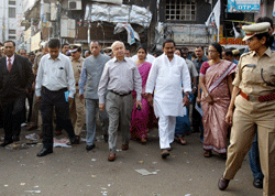 Home Minister Sushilkumar Shinde, center, and Andra Pradesh state Chief Minister Kiran Kumar Reddy, center right in white, leave after visiting the site of one of the two bomb blasts, in Hyderabad, India, Friday, Feb. 22, 2013. Indian police are investigating whether a shadowy Islamic militant group was responsible for a dual bomb attack that killed 16 people outside a movie theater and a bus station in the southern city of Hyderabad, a police official said Friday. AP Photo
