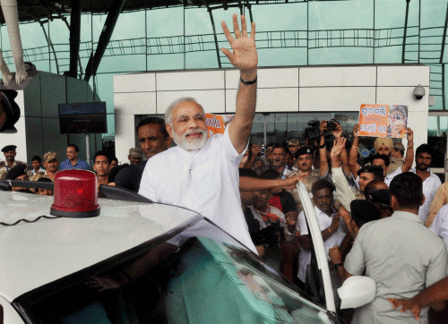 Gujarat Chief Minister Narendra Modi waves on his arrival at Bhubaneswar airport on Tuesday. PTI Photo