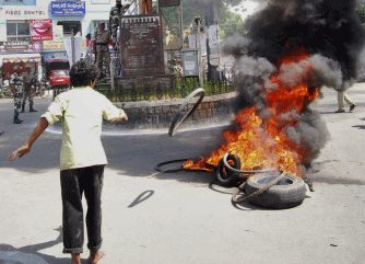 A supporter of United Andhra Pradesh throws a tyre into flames at Tirupati in Chittor district of Andhra Pradesh state 575 kilometers (357 miles) from Hyderabad, India, Friday, Oct. 4, 2013. The approval for the creation of "Telangana" state set off protests in Seemandhra region of Andhra Pradesh Friday. Telangana would become India's 29th state.  AP photo