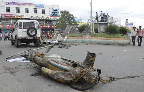 A statue of former prime minister Rajiv Gandhi lies on a road after being vandalized by anti Telangana protestors in Ananthapur in Andhra Pradesh state. AP