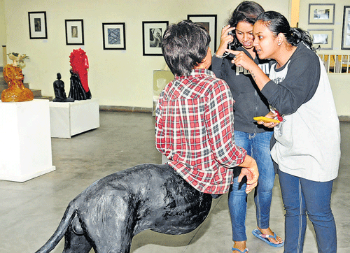 Visitors take a look at an installation at the Karnataka Chitrakala Parishath on Wednesday. DH photo