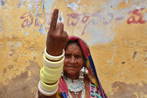 A tribal woman displays the indelible ink mark on her finger after casting her vote at a polling station on the outskirts of Hyderabad, Wednesday, April 30, 2014. AP photo