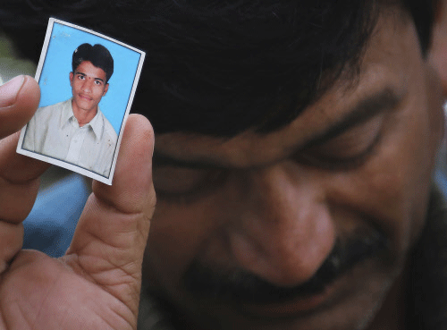 Bonath Shekar Naik shows a portrait of his son Rambabu, only one name available, one of the 24 students feared dead during a field trip near the mountain resort town of Manali, at the college premises of VNR Vignana Jyothi Institute of Engineering and Technology, Hyderabad. AP photo