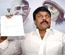 Praja Rajyam Party President Chiranjeevi showing his resignation letter during a media conference in Hyderabad on Thursday. PTI