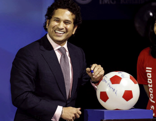 co-owner of the Kerala Blasters soccer team Sachin Tendulkar signs a soccer ball replica during the emblem-unveiling ceremony of the Indian Super League in Mumbai August 28, 2014.  Reuters photo