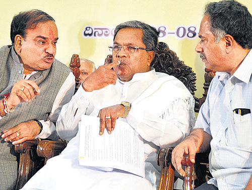 Union Minister of Chemicals and Fertilisers H N Ananth Kumar is having a word with Chief Minister Siddaramaiah and State Chief Secretary Kaushik Mukherjee at the inauguration  of the Pradhan Mantri Jan Dhan Yojana project in Bangalore on Thursday. DH PHOTO