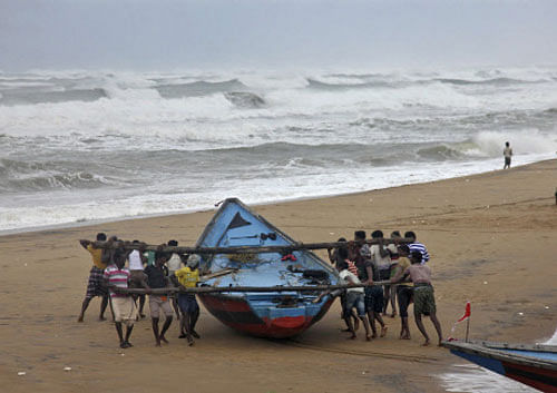 Fishermen move a fishing boat to a safer place along the shore ahead of cyclone Hudhud at Ganjam district. Reuters photo