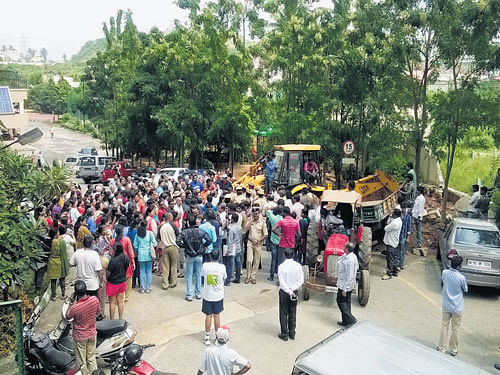 Residents of Mantri Tranquil apartments off Kanakapura Road in Gubbalala village near Uttarahalli staged a protest on Tuesday as the BBMP officials began clearing encroachment on a stormwater drain. DH Photo