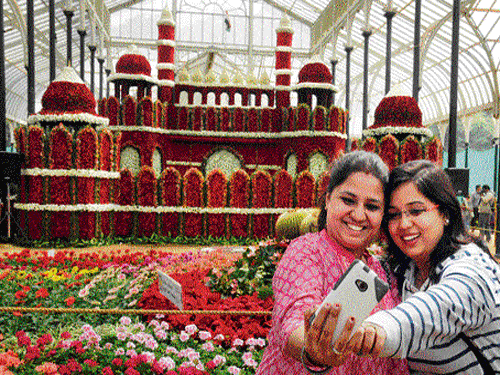 say rose! Visitors take a selfie in front of a flower model of the Red Fort at the Republic Day flower show organised by the  Department of Horticulture and Mysore Horticultural Society at the Glass House in Lalbagh. (Below) A floral replica of the  guitar on display. dh Photos