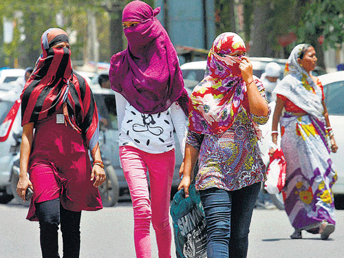Women cover their faces to beat the heat on a hot day in Allahabad on Friday. PTI