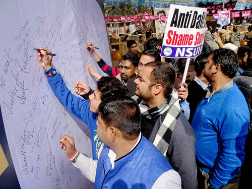NSUI students signing a board during a signature protest over Rohith Bemula's suicide at Delhi University on Monday. PTI Photo.