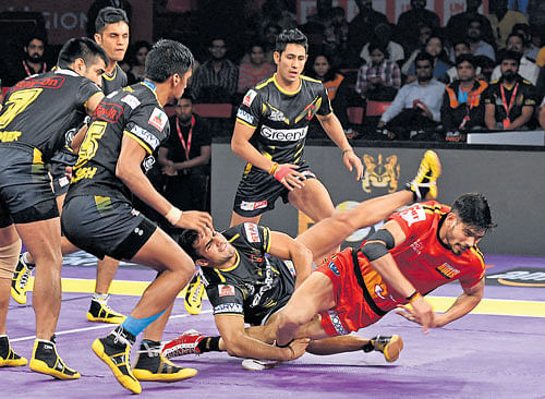 So close! Bengaluru Bulls' Rohith Kumar (right) tries to complete his raid against Telugu Titans. dh photo/ srikanta sharma r