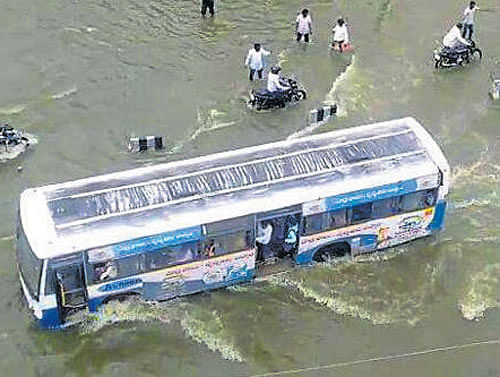 A bus passes through a  flooded road in Hyderabad on Friday. DH Photo