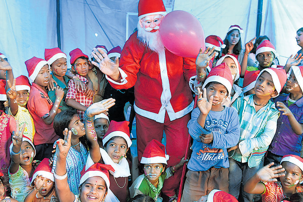 Children of construction workers in Koramangala have a good time with Santa Claus as part  of Christmas celebrations organised by The Magic Lantern on Sunday. DH&#8200;PHOTO