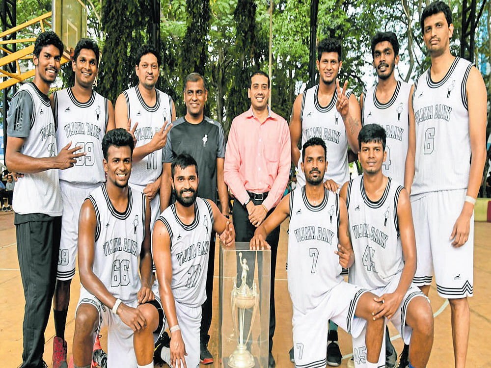 Champions: Vijaya Bank team, winners of the State 'A' Division basketball league on Tuesday. From left (standing): Clinton Andrew, Deva Kumar, Ashraf Ali, Rajkumar (coach), Shyam Ponnappa (sports officer), Arvind Arumugam, Roby Thomas, Sanjay Raj. Kneeling: Karthikeyan, Rajesh Uppar, Anil Kumar, Navin Raj.  Dh photo