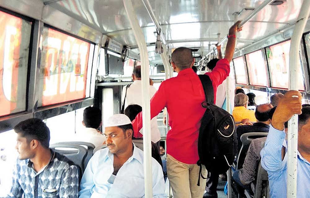 Passengers standing in a BMTC bus cannot see outside  because of advertisements on glass panels.  DH photo by Chiranjeevi Kulkarni