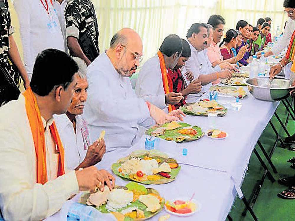 BJP president Amit Shah has lunch during his door-to-door campaign in a Dalit colony at Theratpally Village, Nalgonda, on Monday. PTI