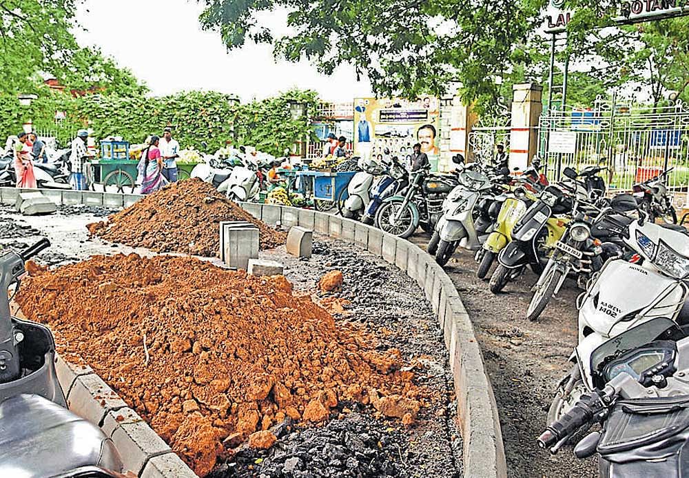Work on the construction of a traffic island has eaten into  the parking space in front of the Siddapura Gate of Lalbagh.  dh photo