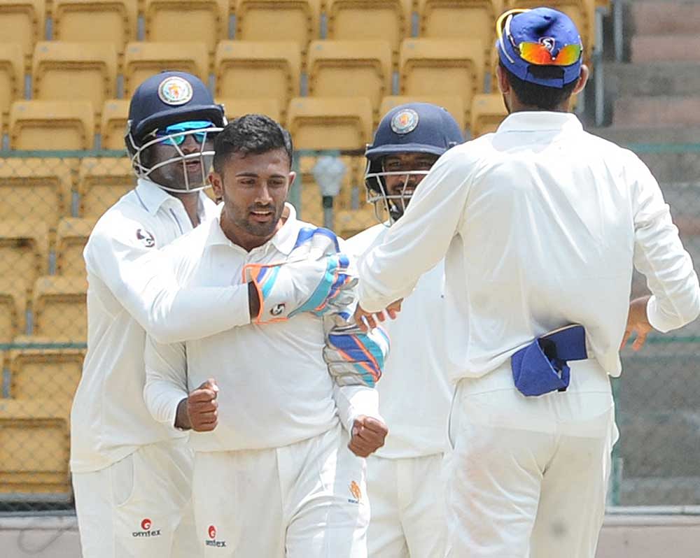 Wrecker-in-chief: Shreyas Gopal (centre) of KSCA XI is congratulated by team-mates after                    dismissing Abu Nechim of Assam at the Chinnaswamy stadium on Tuesday. DH PHOTO