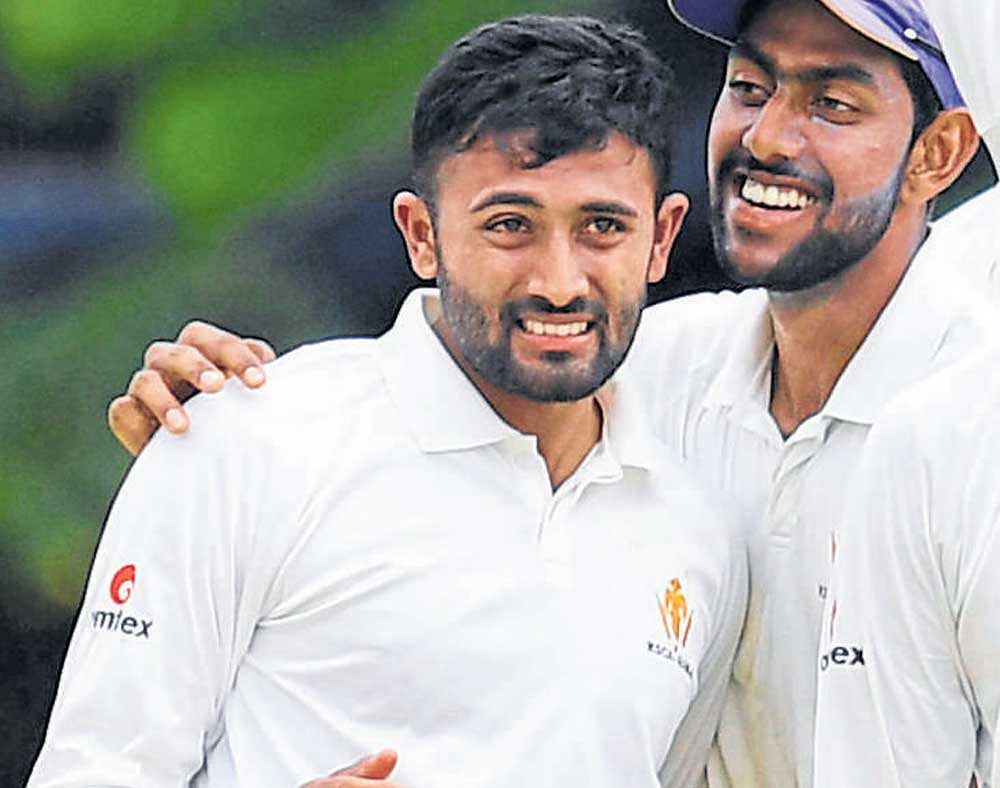 Shreyas Gopal (left) of KSCA XI is congratulated by team-mate J Suchith after the fall of a Tripura batsman at the RSI ground on Thursday. DH PHOTO