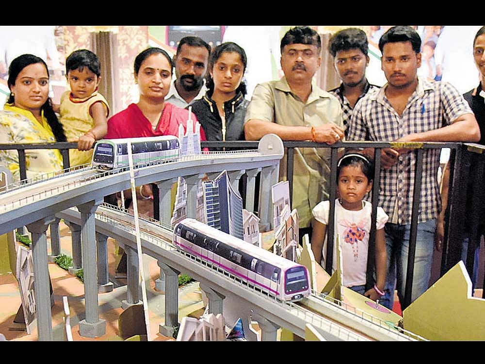 Visitors take a look at a model of the Metro train at the state government's stall at the Independence Day flower show at Lalbagh on Wednesday. DH photo