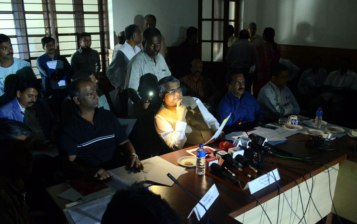 Legislative Assembly Speaker K B Koliwad uses cell phone flashlight to read out a press note after the power went off during the media briefing at Suvarna Vidhana Soudha in Belagavi on Sunday. DH photo