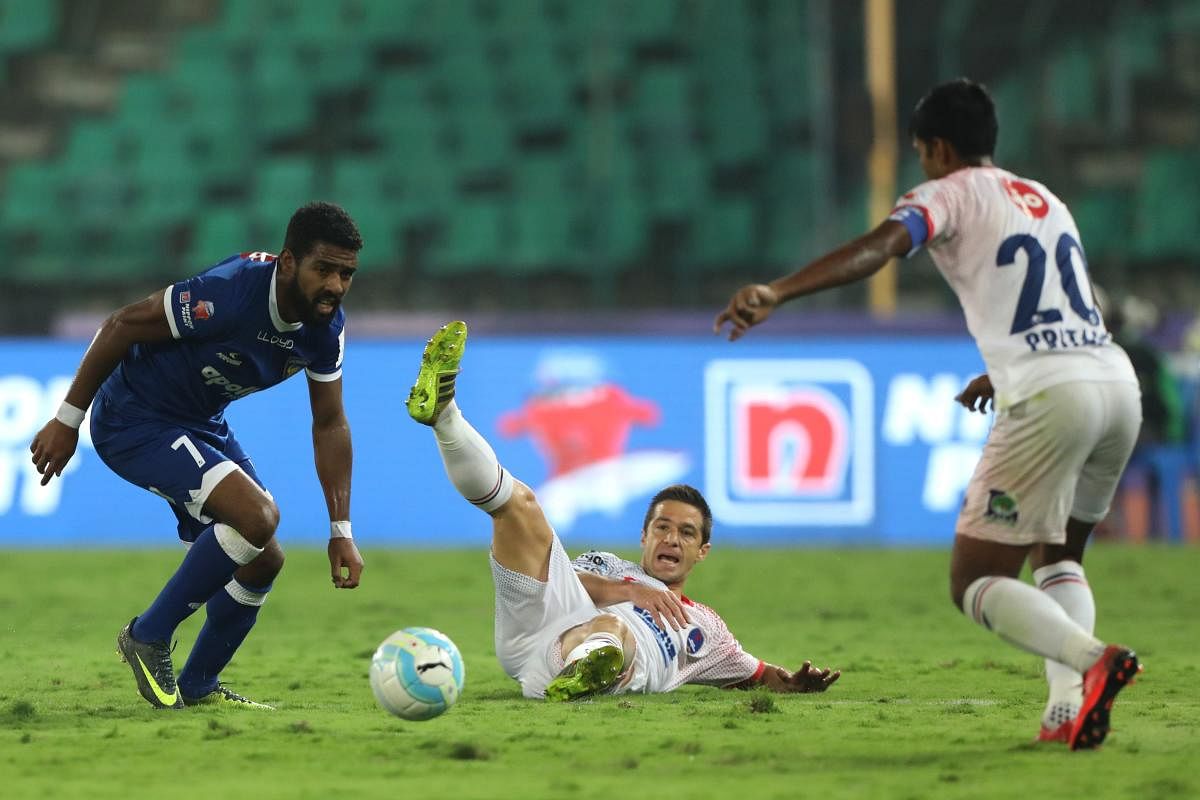 KEEN TUSSLE Chennaiyin FC's Gregory Nelson (left) attempts to get past FC Pune City defenders on Saturday. ISL MEDIA