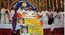 Chief Minister handing over health insurance scheme to a beneficiary in Udupi on Friday.