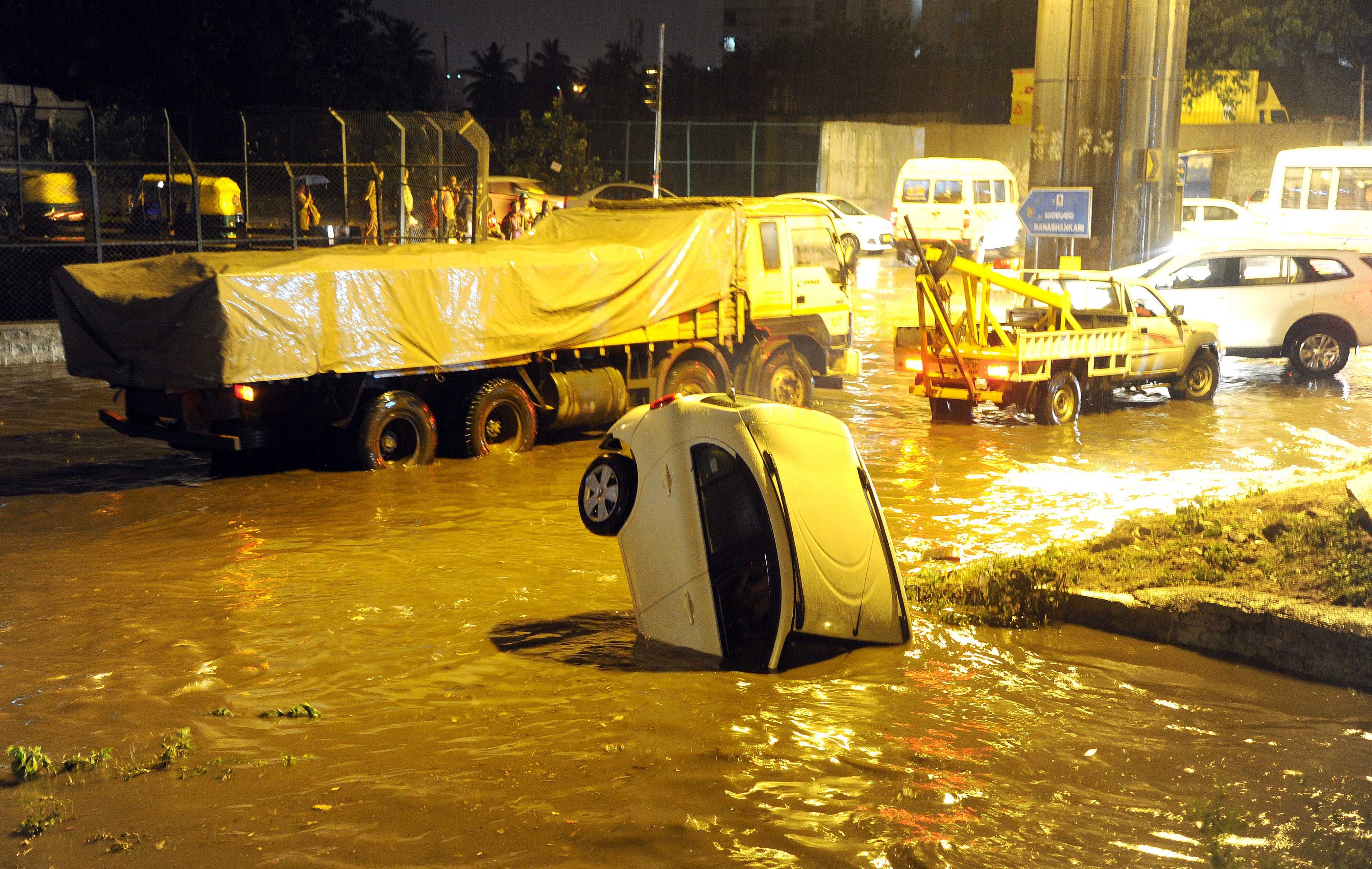 A car stuck under the Nayandahalli flyover after heavy rain lashed Bengaluru recently. (DH File Photo/Srikanta Sharma R)