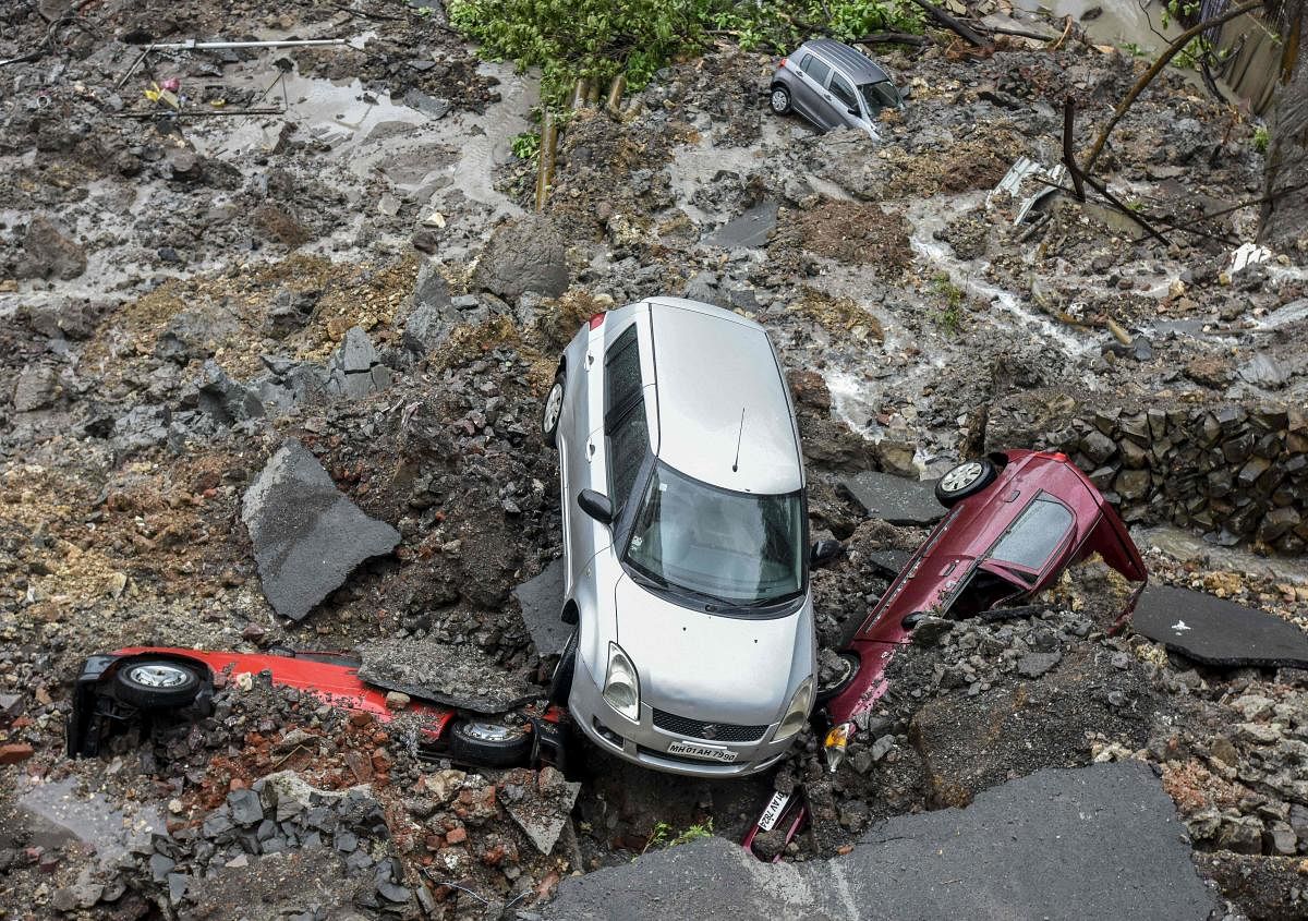 Damaged vehicles are pictured amongst debris after a landslide following heavy monsoon rain showers in Mumbai. AFP